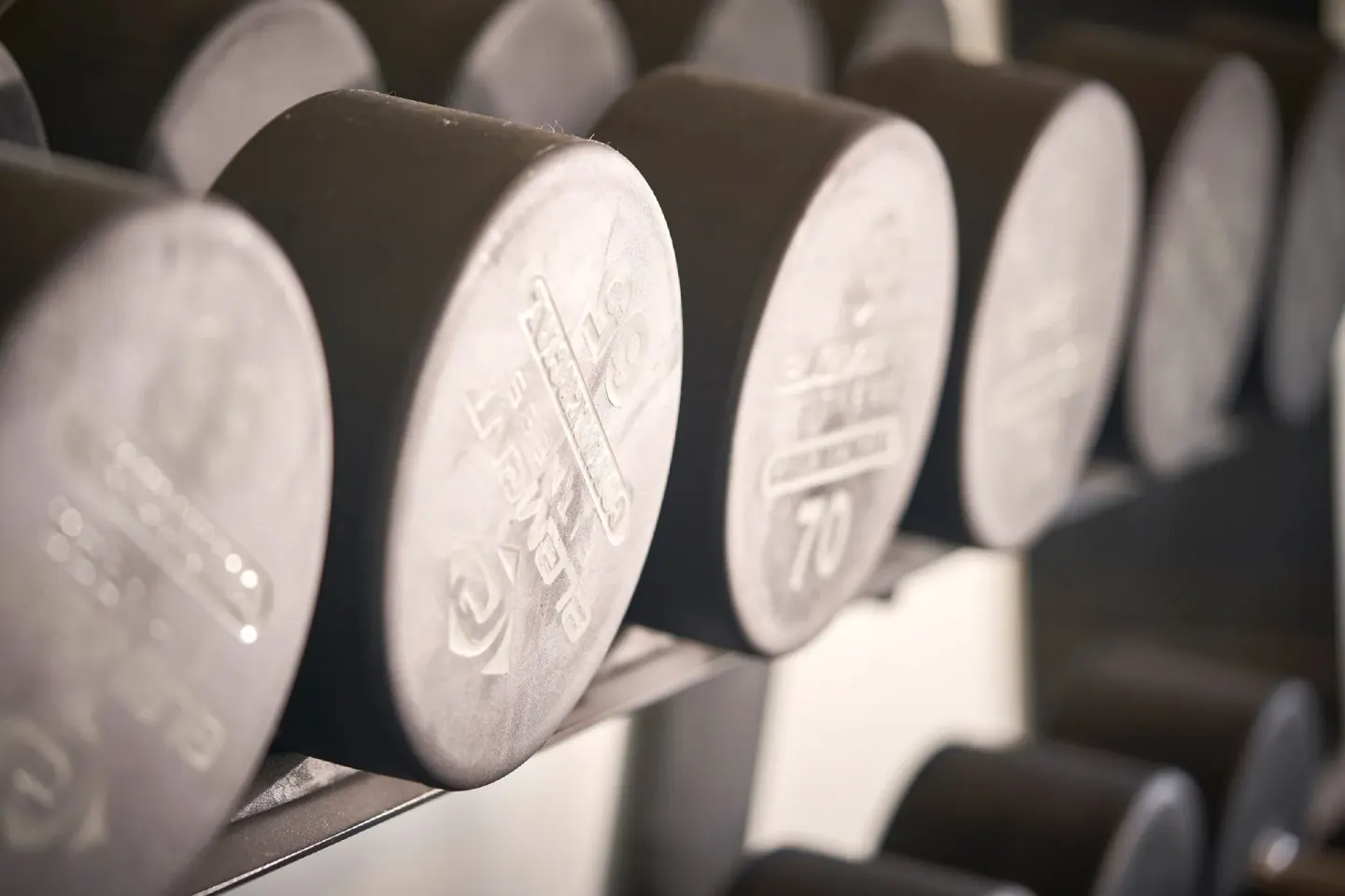 Close-up of dumbbells on a rack in the fitness center at Royalton Grenada.