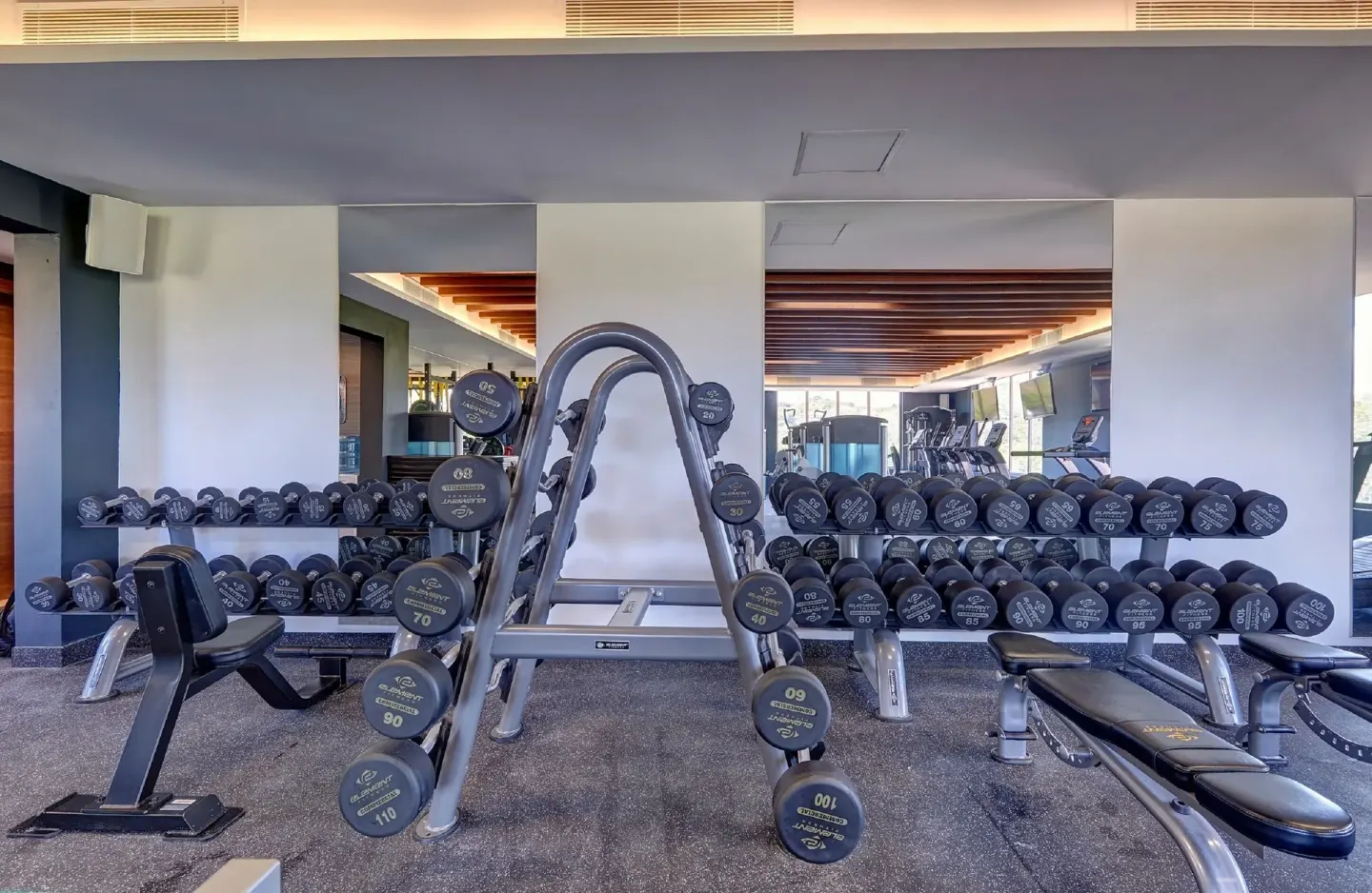 Free weights and benches in the fitness center at Royalton Grenada.
