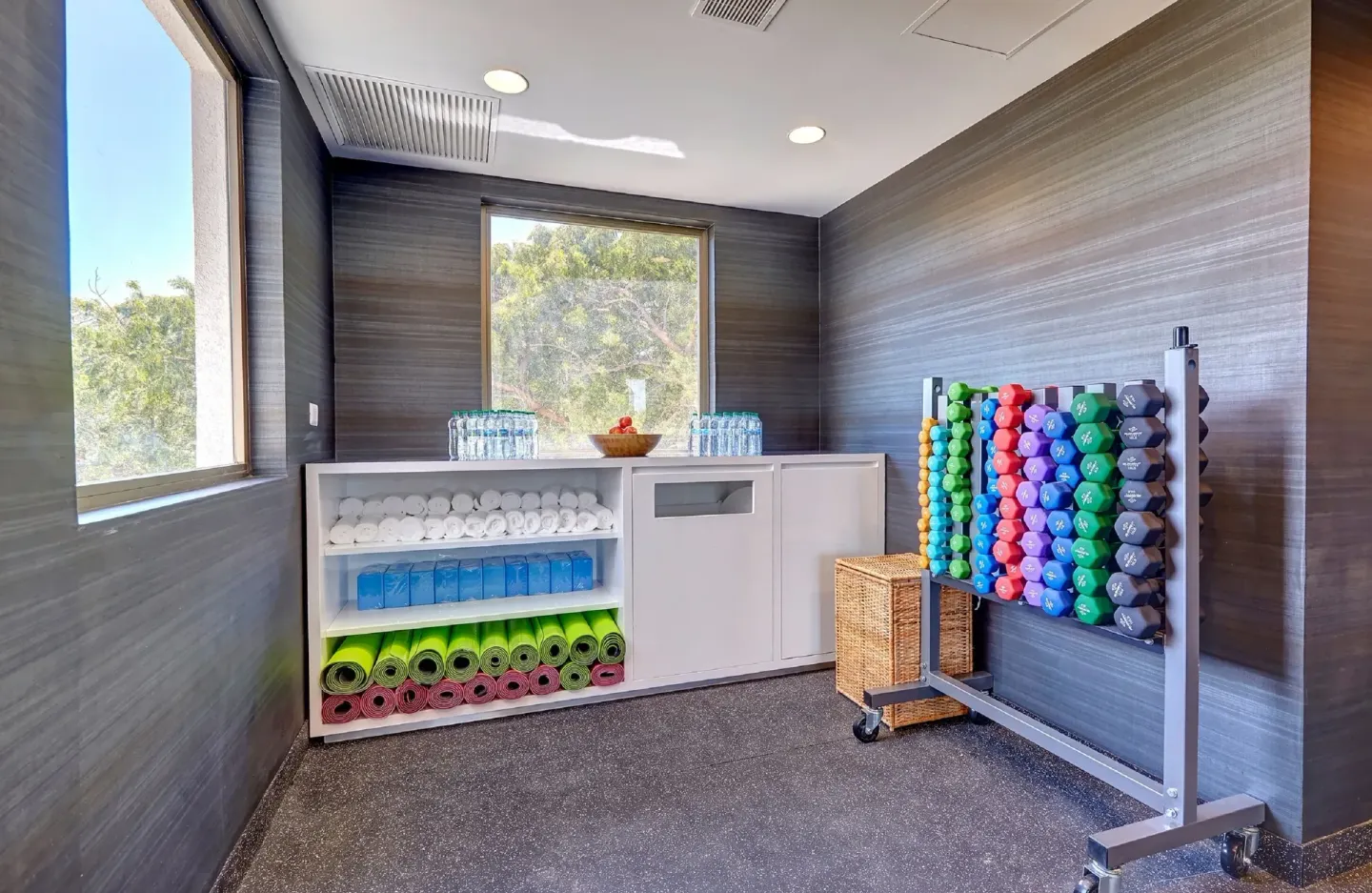 Yoga mats, towels, water, and colorful dumbbells in the fitness center at Royalton Grenada.
