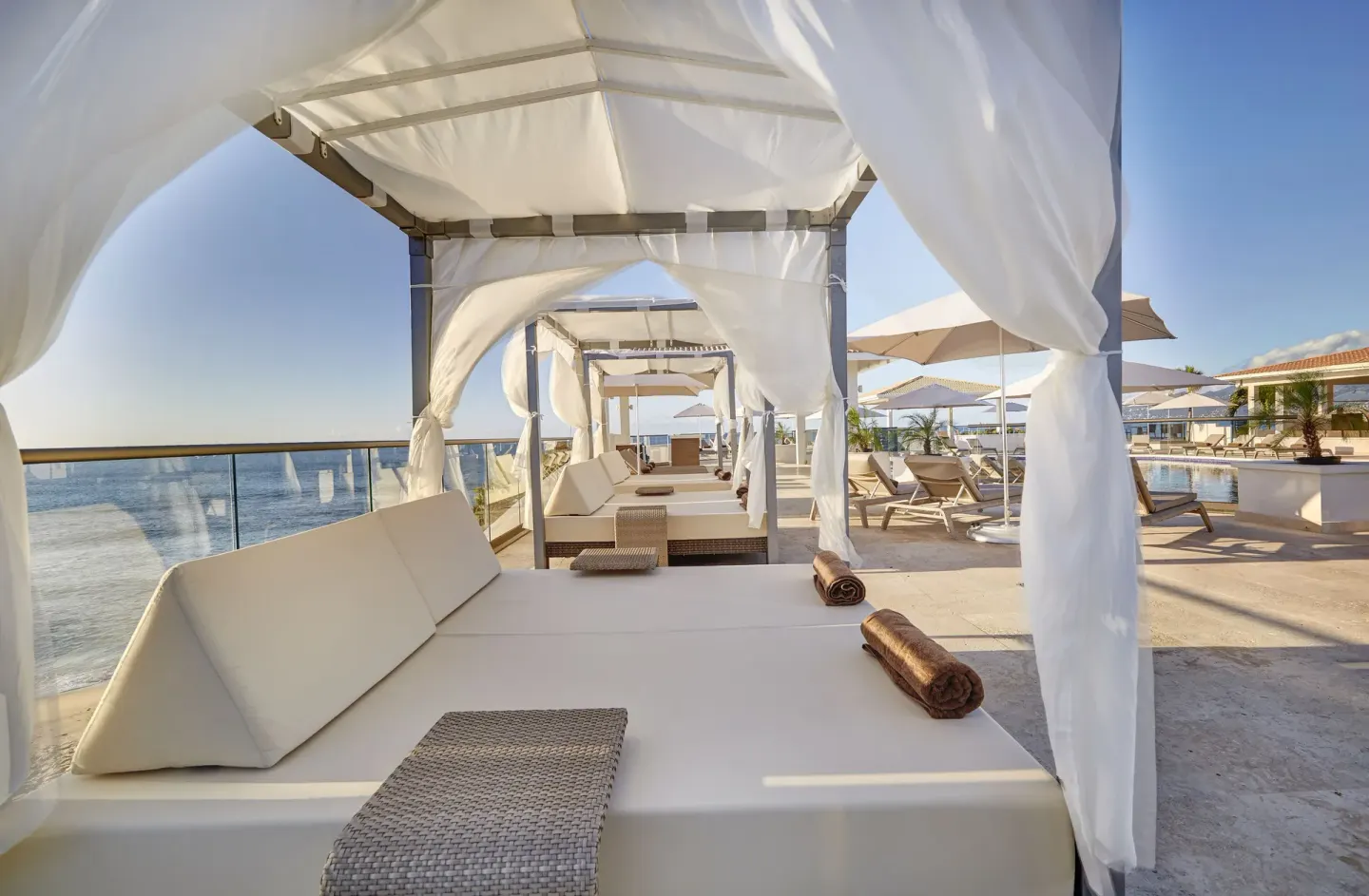 Oceanfront cabana bed with white drapes on a sun deck at Royalton Grenada.