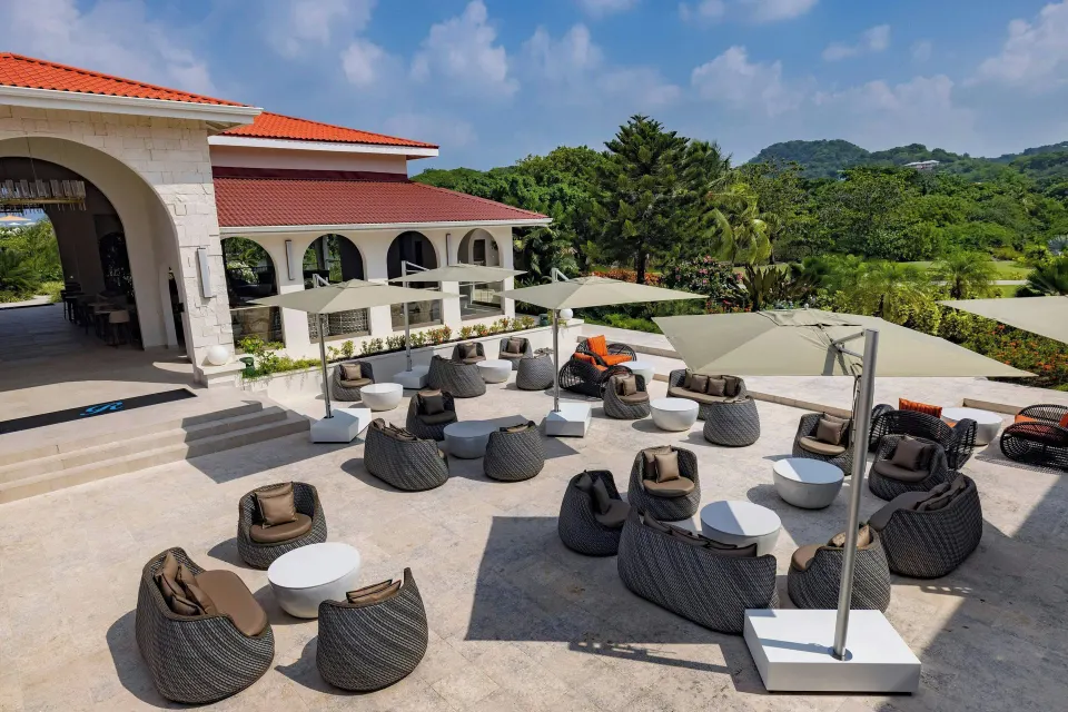 Outdoor terrace lounge with umbrellas and wicker chairs at Royalton Grenada.