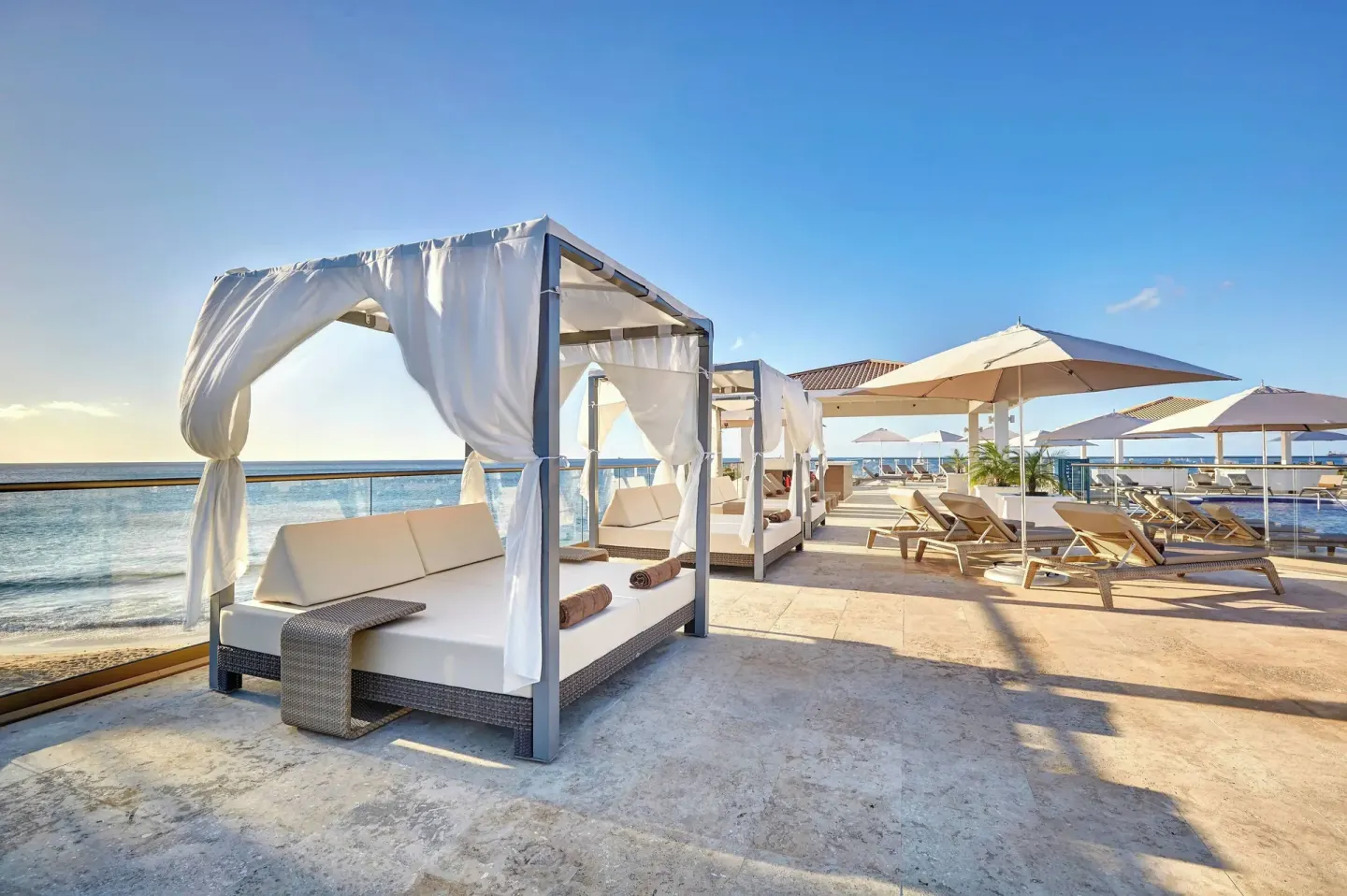 Seaside sun deck with cabanas, loungers, and umbrellas at Royalton Grenada.