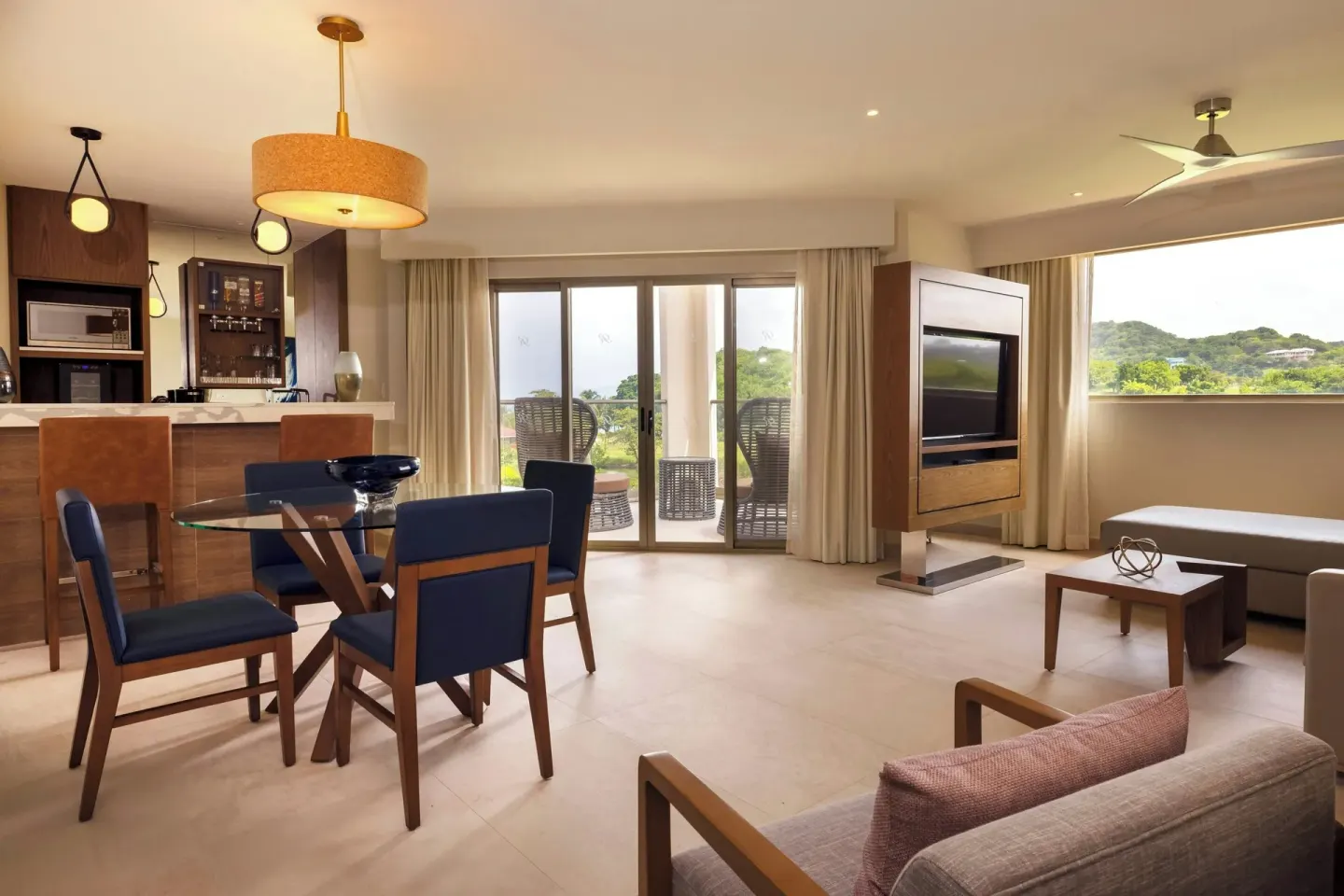 Spacious suite living and dining room with balcony doors at Royalton Grenada.