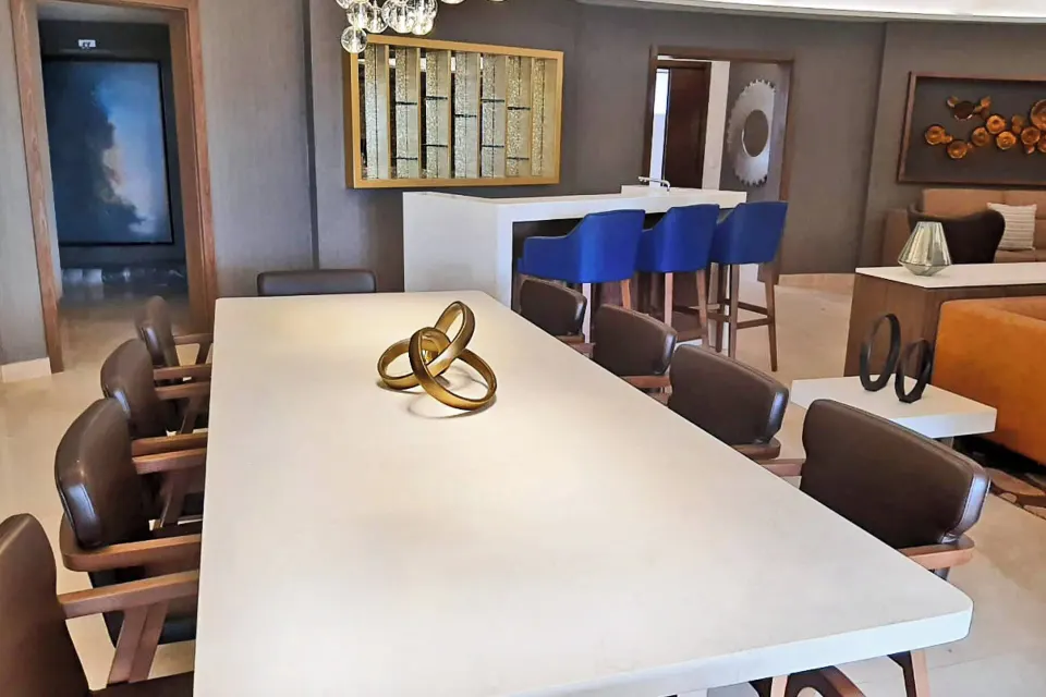 Suite dining area with long table and blue bar stools at Royalton Grenada.