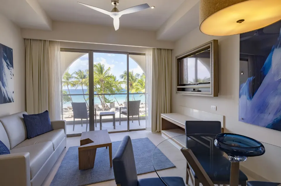 Living area of a Presidential Ocean Front One Bedroom Suite at Royalton Grenada with balcony and sea view.