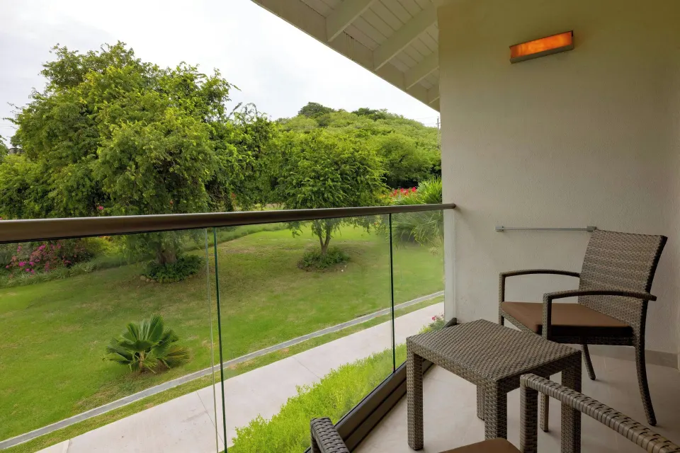 Luxury Room balcony with seating and garden view at Royalton Grenada.
