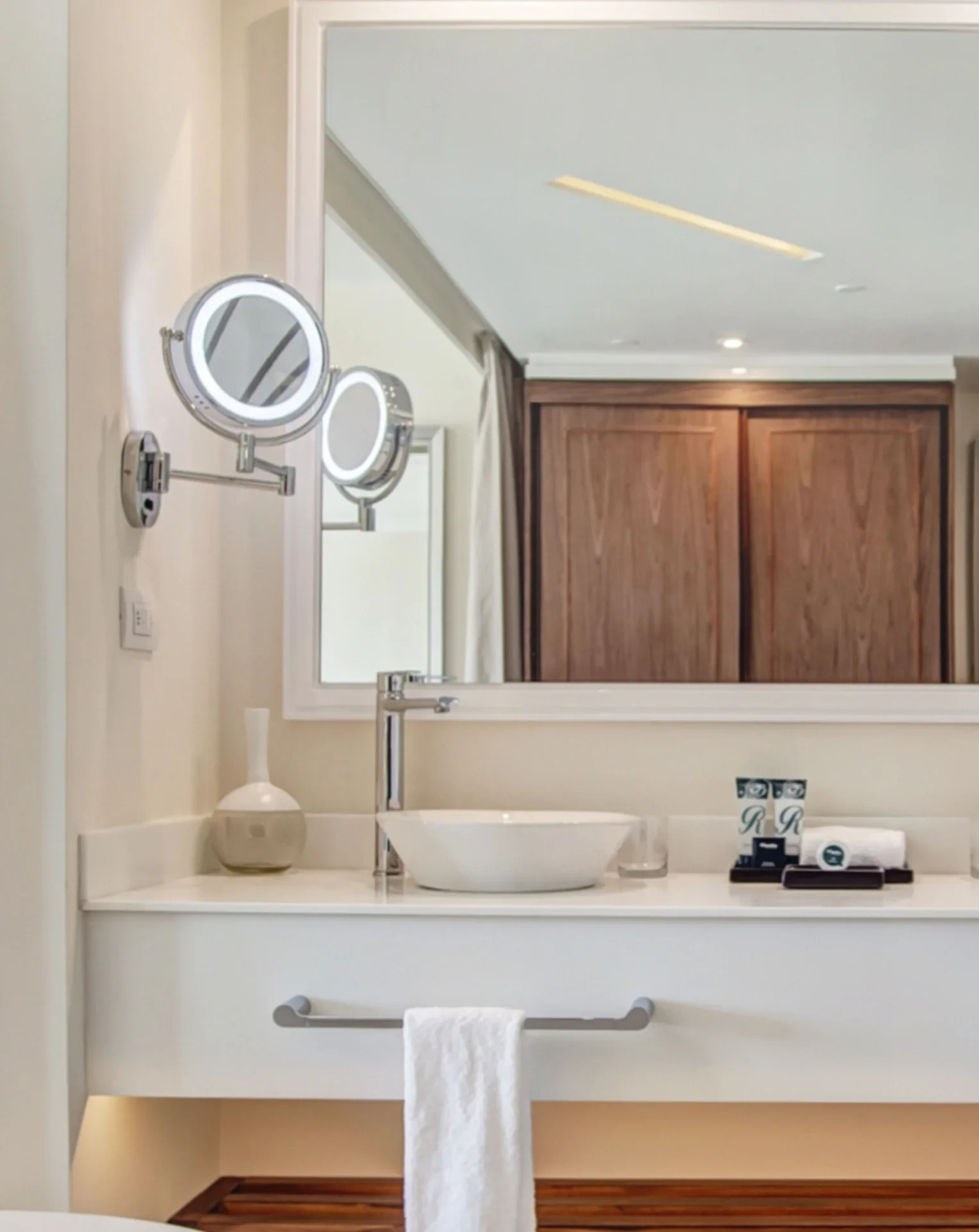 Luxury Room bathroom sink at Royalton Grenada with round vanity mirrors and towels.