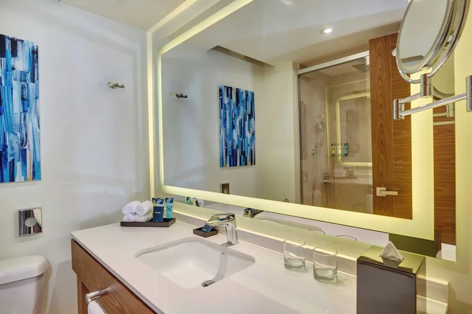 Luxury Room bathroom vanity with lit mirror and shower at Royalton Grenada.
