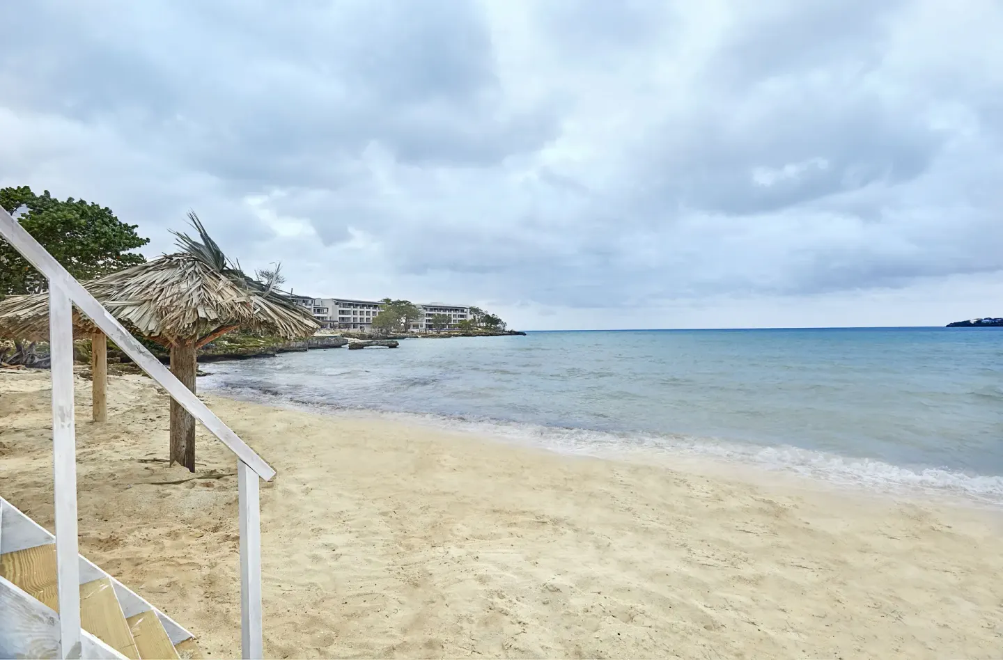 Sandy beach with a thatched shade and ocean view at Royalton Hideaway Negril.