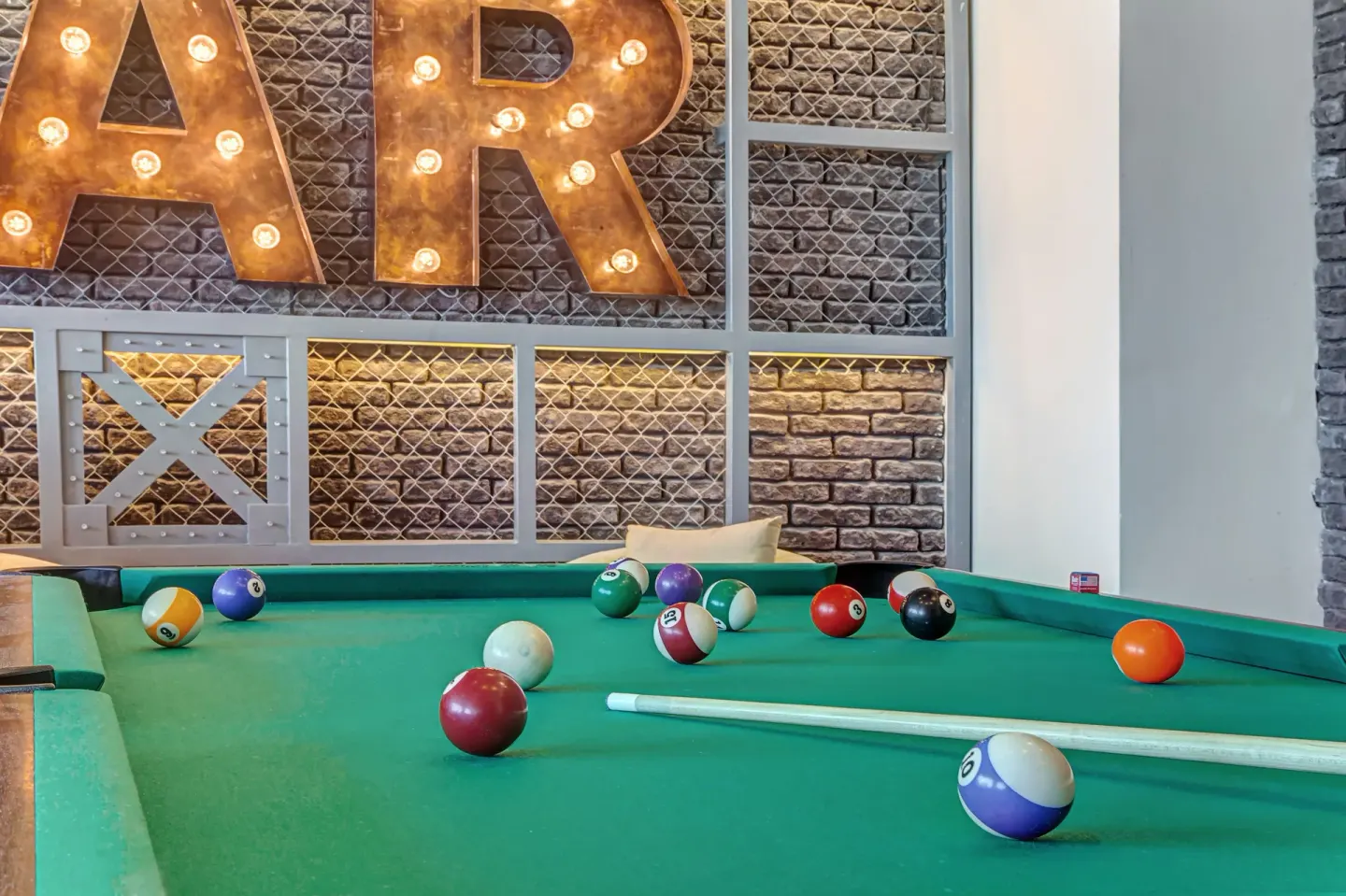 Pool table with scattered billiard balls in the game area at Royalton Hideaway Negril.
