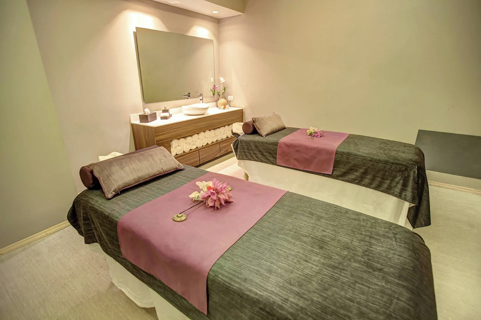 Two treatment beds with floral accents in a spa room at Royalton Hideaway Negril.