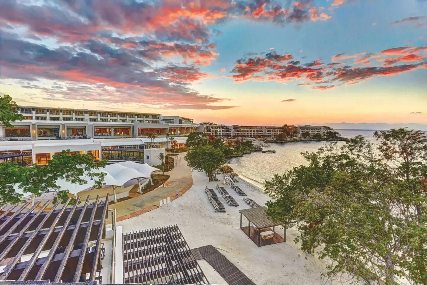 Elevated sunset view of beach, loungers and resort buildings at Royalton Hideaway Negril.