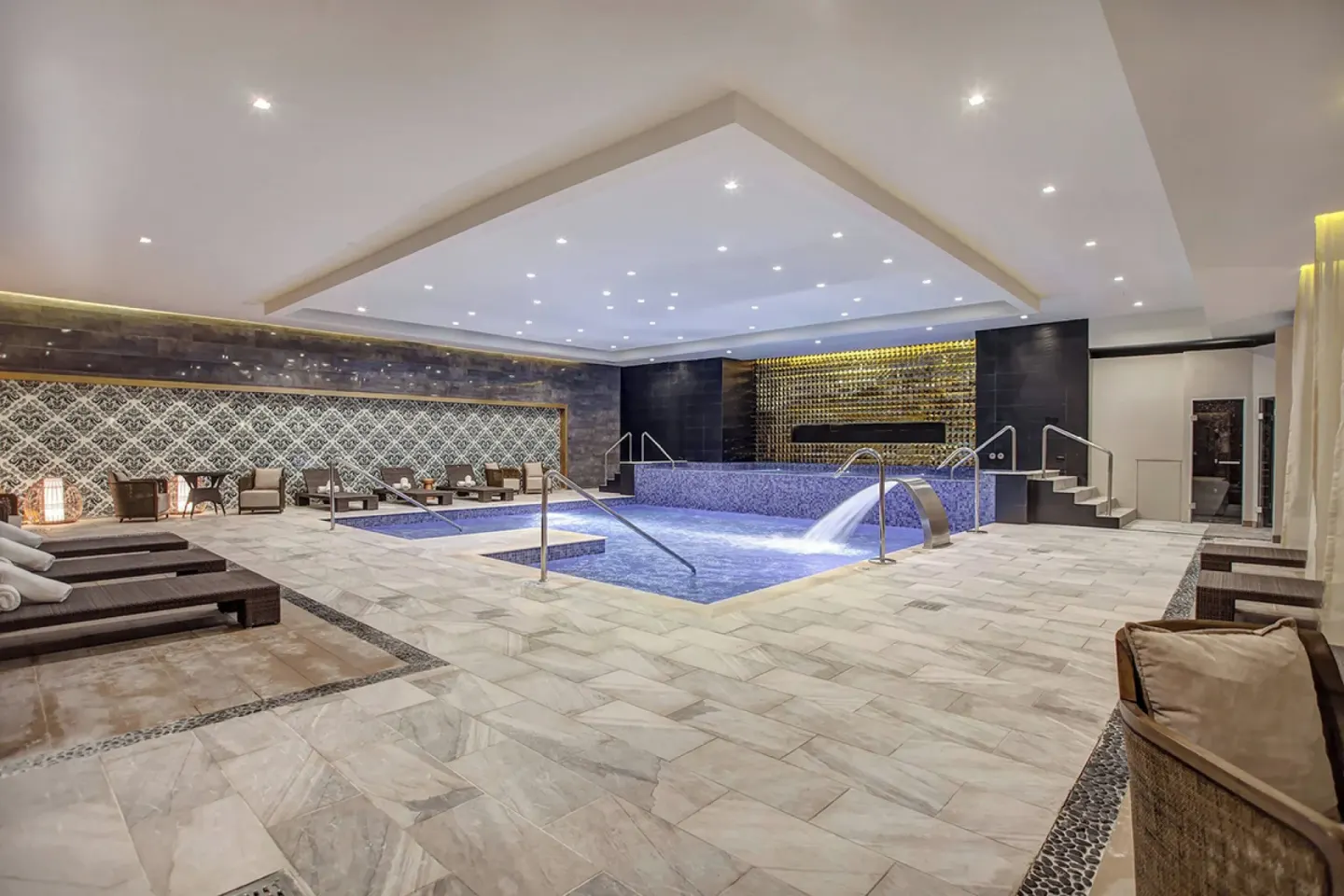 Indoor hydrotherapy pool with loungers and tiled walls at Royalton Hideaway Negril.