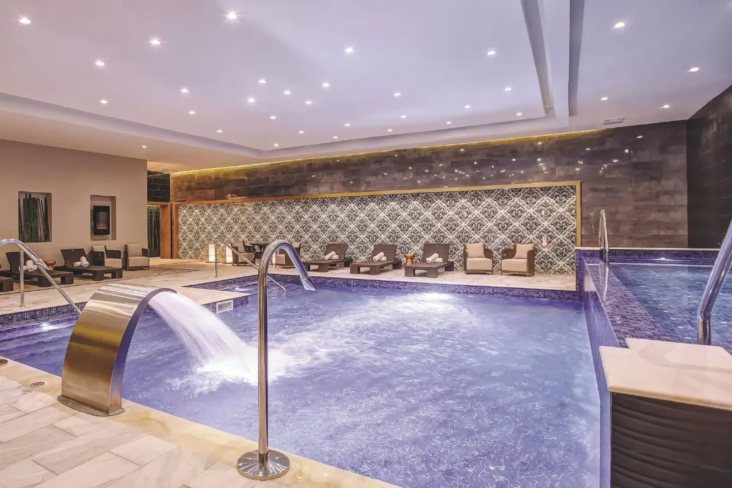 Indoor spa pool with metal water spouts and lounge seating at Royalton Hideaway Negril.