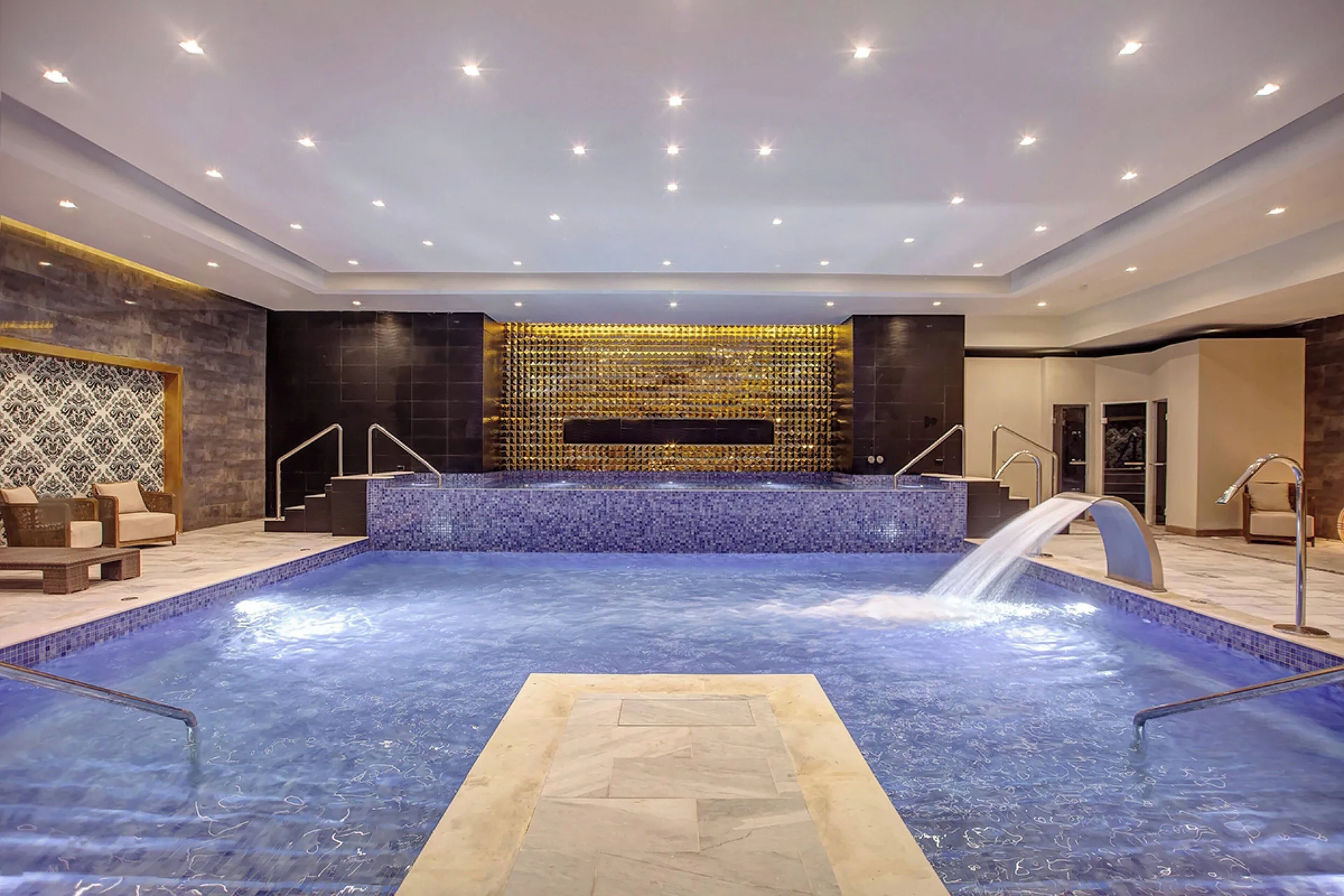 Blue indoor spa pool with a curved water feature at Royalton Hideaway Negril.