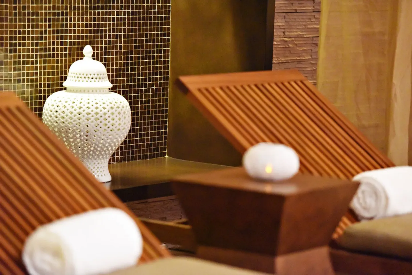 Wooden spa loungers, towels, and a decorative lantern at Royalton Hideaway Negril.