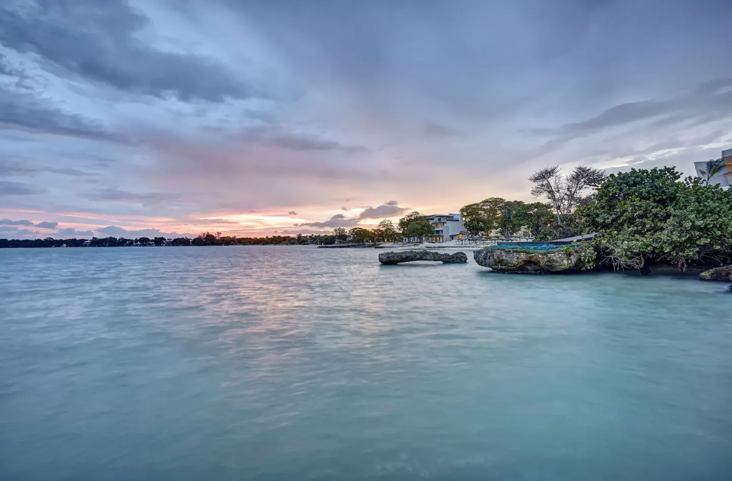 Calm bay water, rocky outcrops and sunset sky at Royalton Hideaway Negril.