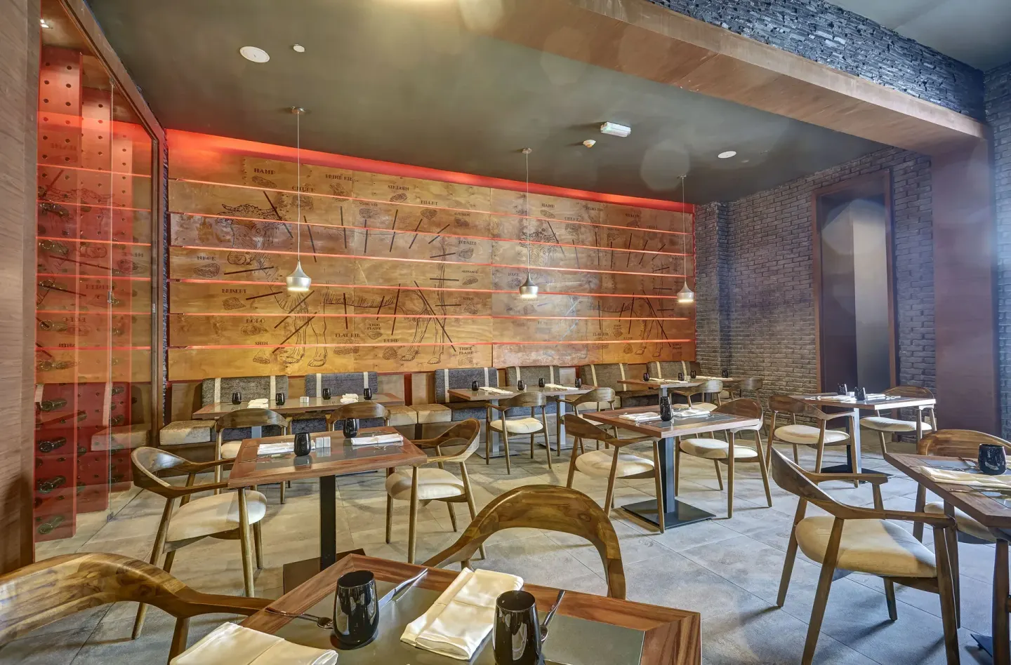 Steakhouse dining room with wood wall panels and red lighting at Royalton Hideaway Negril.