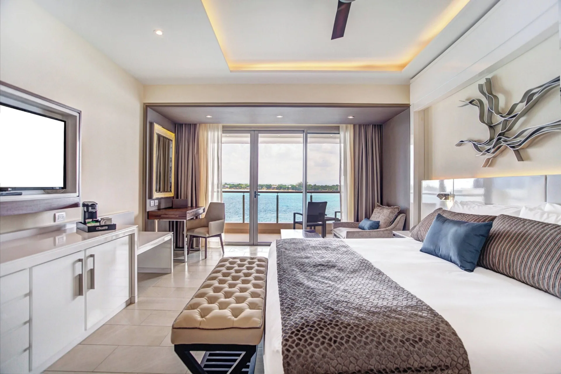 King bed and ocean-facing balcony in a Luxury Junior Suite Ocean View at Royalton Hideaway Negril.