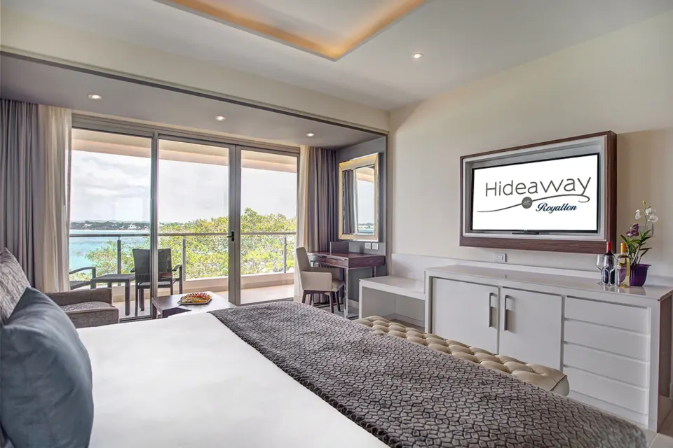 Luxury Junior Suite Ocean View with king bed, TV, and balcony at Royalton Hideaway Negril.