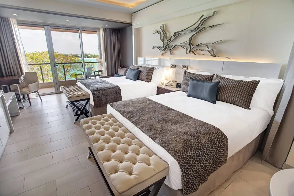 Luxury Junior Suite Ocean View two-bed room with ocean-facing balcony at Royalton Hideaway Negril.