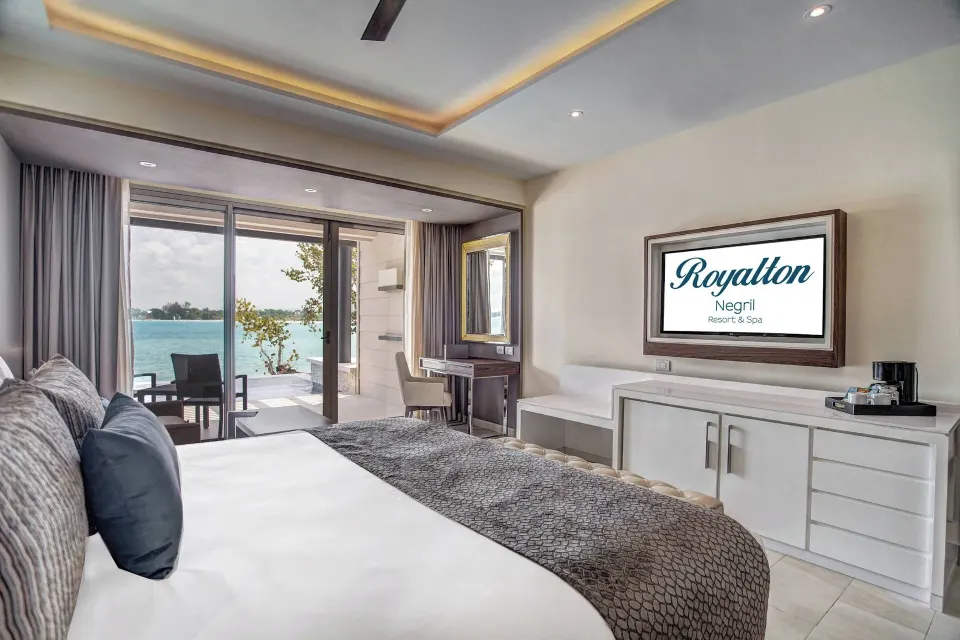 Luxury Junior Suite Swim Out with king bed, TV wall, and terrace at Royalton Hideaway Negril.