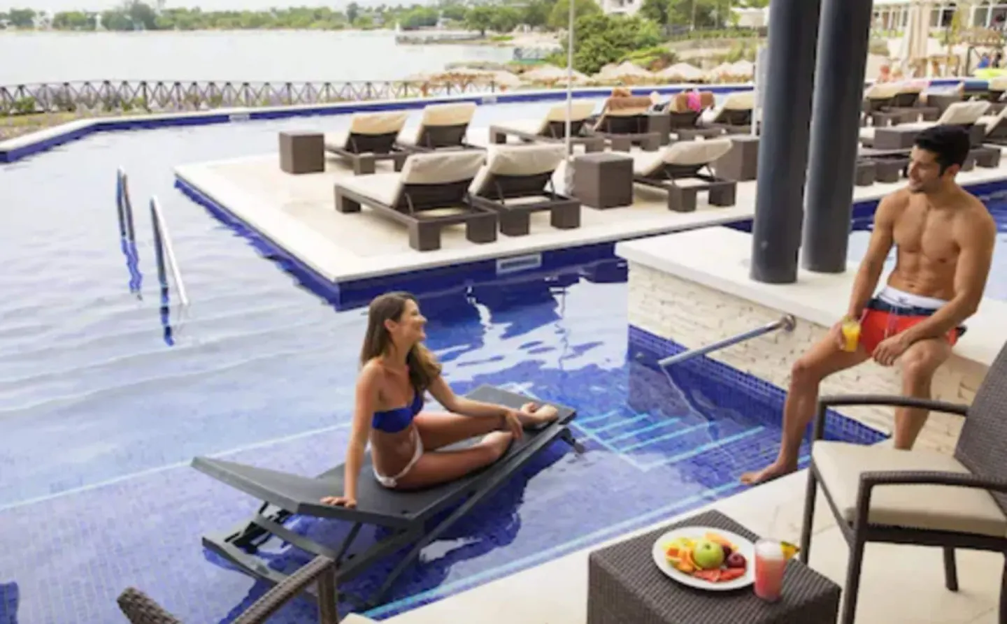 Luxury Junior Suite Swim Out pool terrace at Royalton Hideaway Negril with loungers and guests by the water.