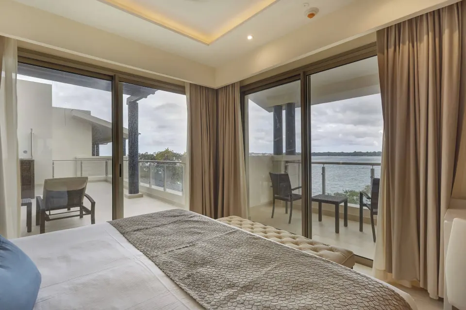Penthouse bedroom with balcony seating and water view at Royalton Hideaway Negril.