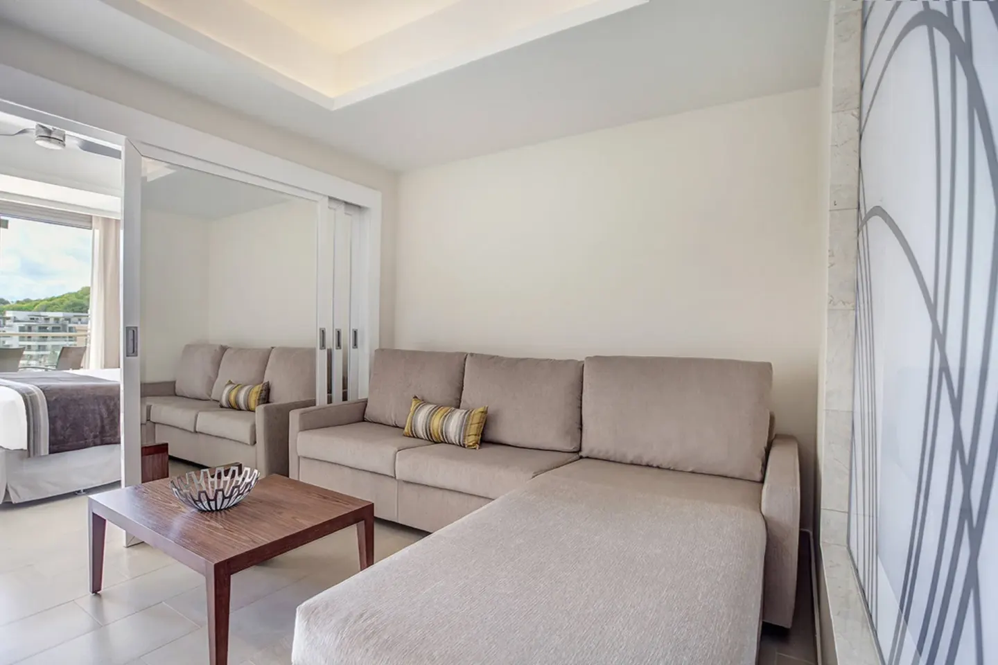 Penthouse lounge sofa with bedroom visible at Royalton Hideaway Negril.