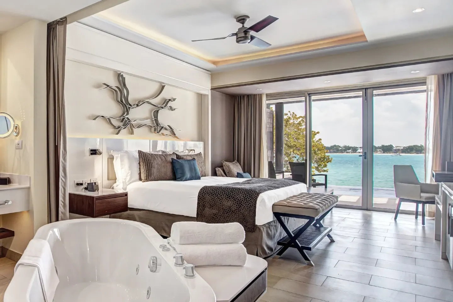 Presidential suite king bed and soaking tub with ocean view at Royalton Hideaway Negril.