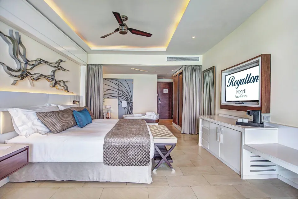 King bed and TV wall in the Presidential suite at Royalton Hideaway Negril.