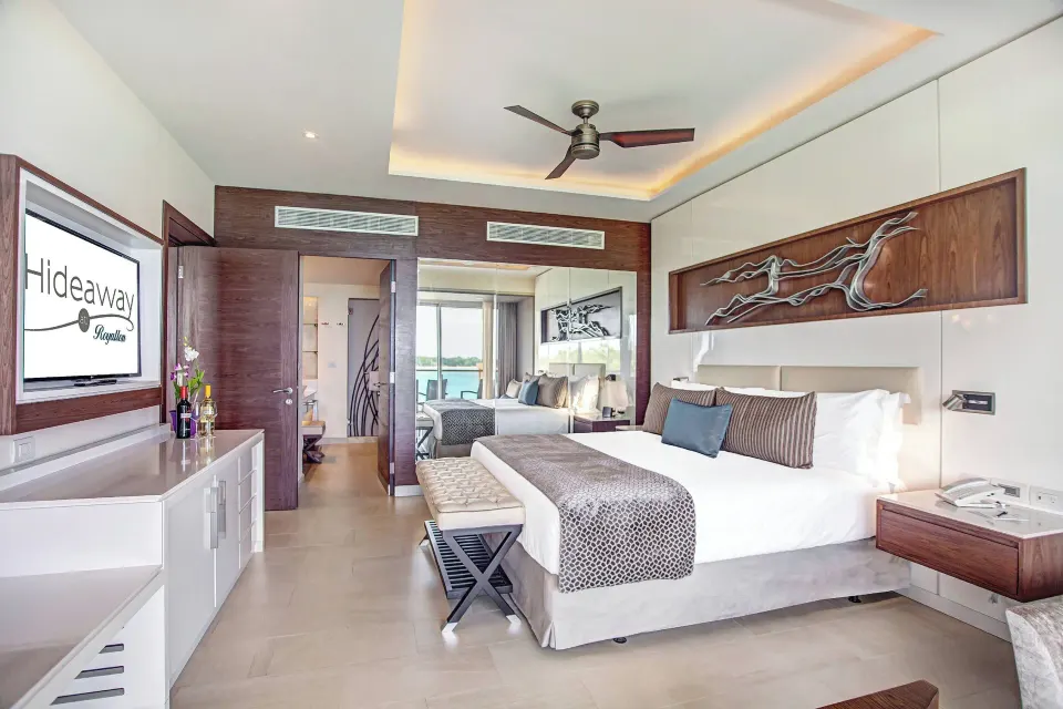 Presidential suite king bedroom with TV and ocean glimpse at Royalton Hideaway Negril.