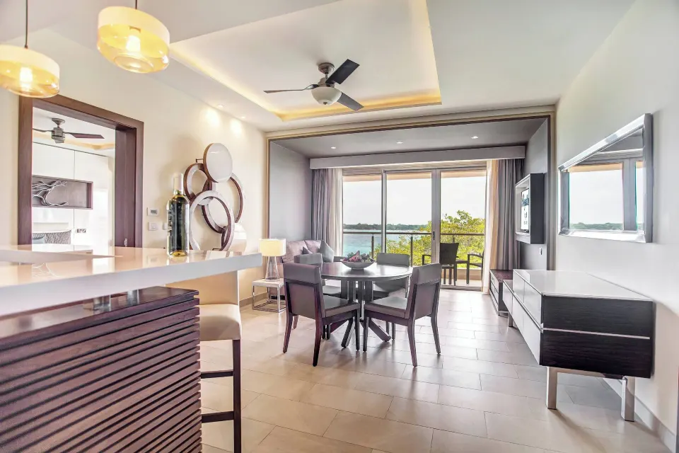 Presidential suite lounge with dining table and ocean balcony at Royalton Hideaway Negril.