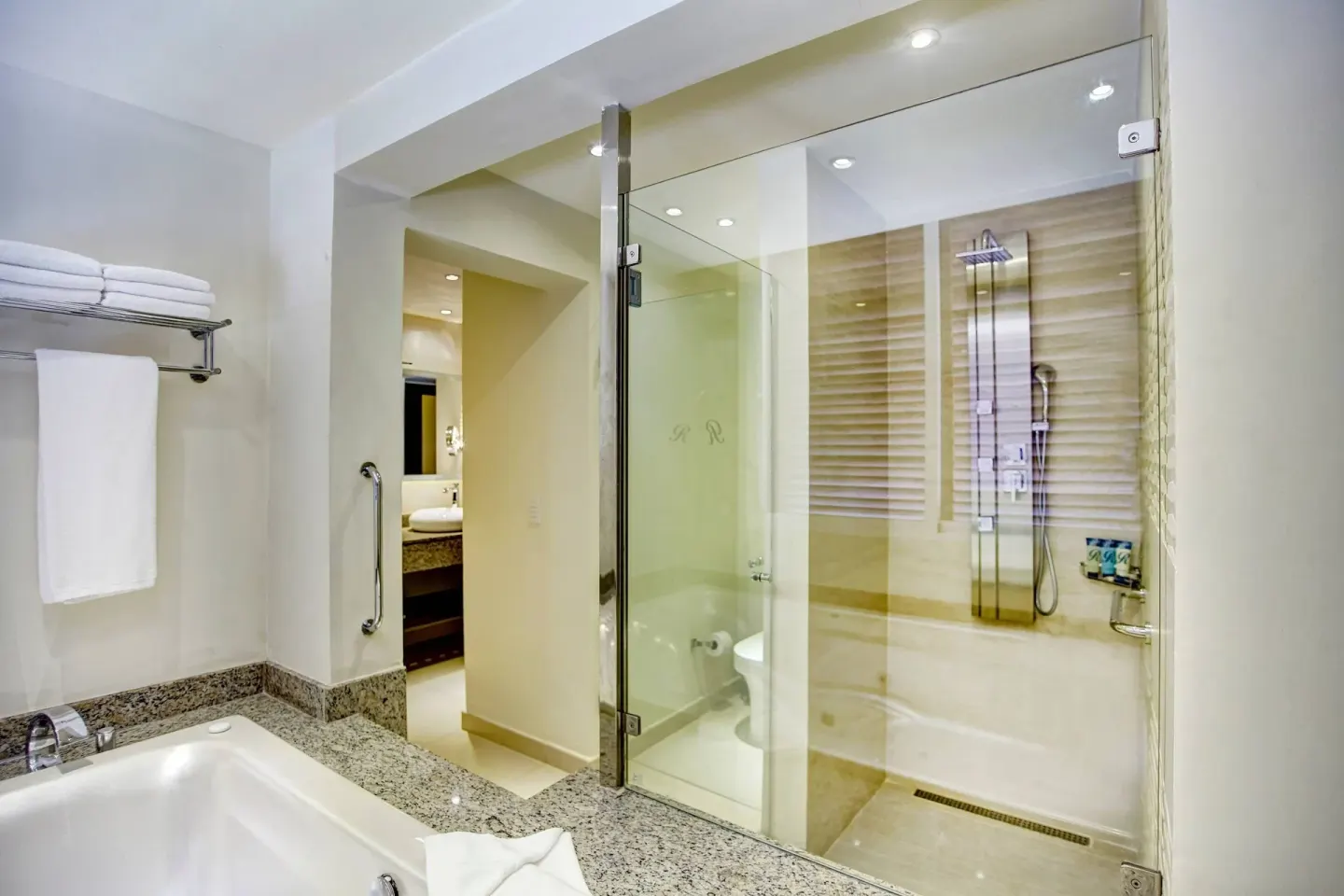 Bathroom with tub, towel shelf and glass shower at Royalton Hideaway Punta Cana Resort & Casino.
