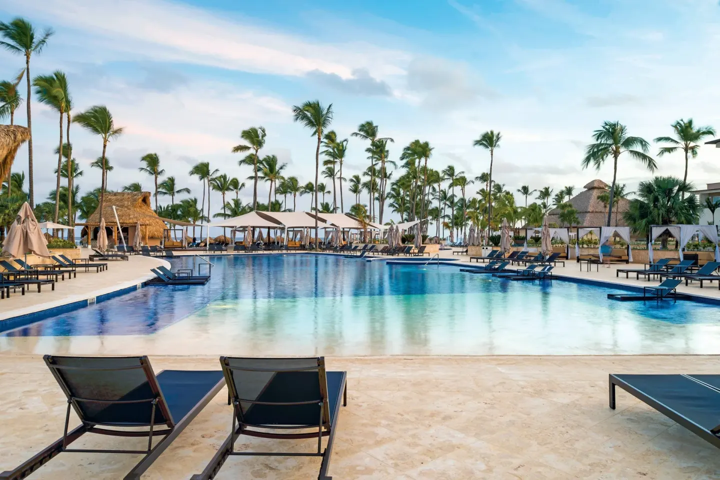 Large resort pool with loungers and palms at Royalton Hideaway Punta Cana Resort & Casino.