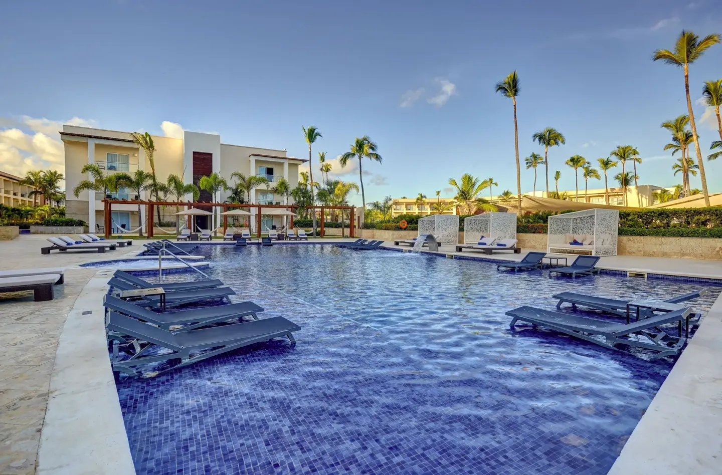 Resort pool with in-water loungers and palms at Royalton Hideaway Punta Cana Resort & Casino.