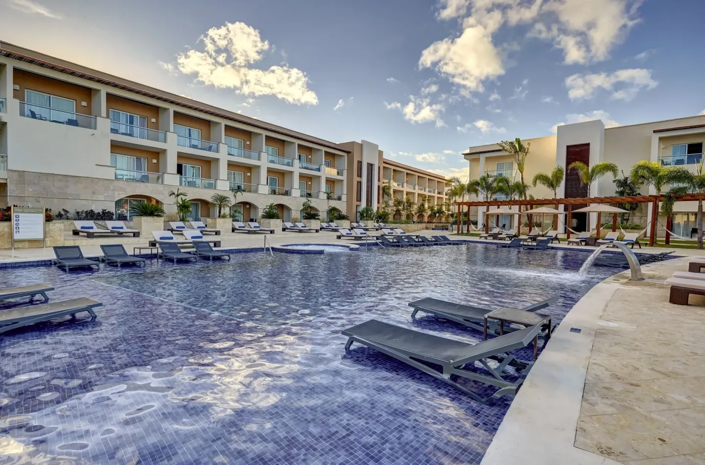Resort pool with in-water loungers and room balconies at Royalton Hideaway Punta Cana Resort & Casino.