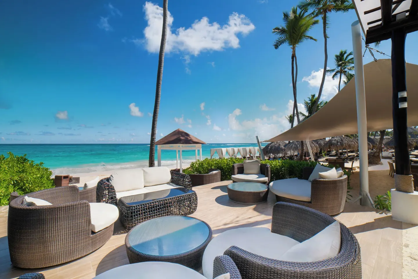 Oceanfront lounge chairs on a shaded terrace at Royalton Hideaway Punta Cana Resort & Casino.