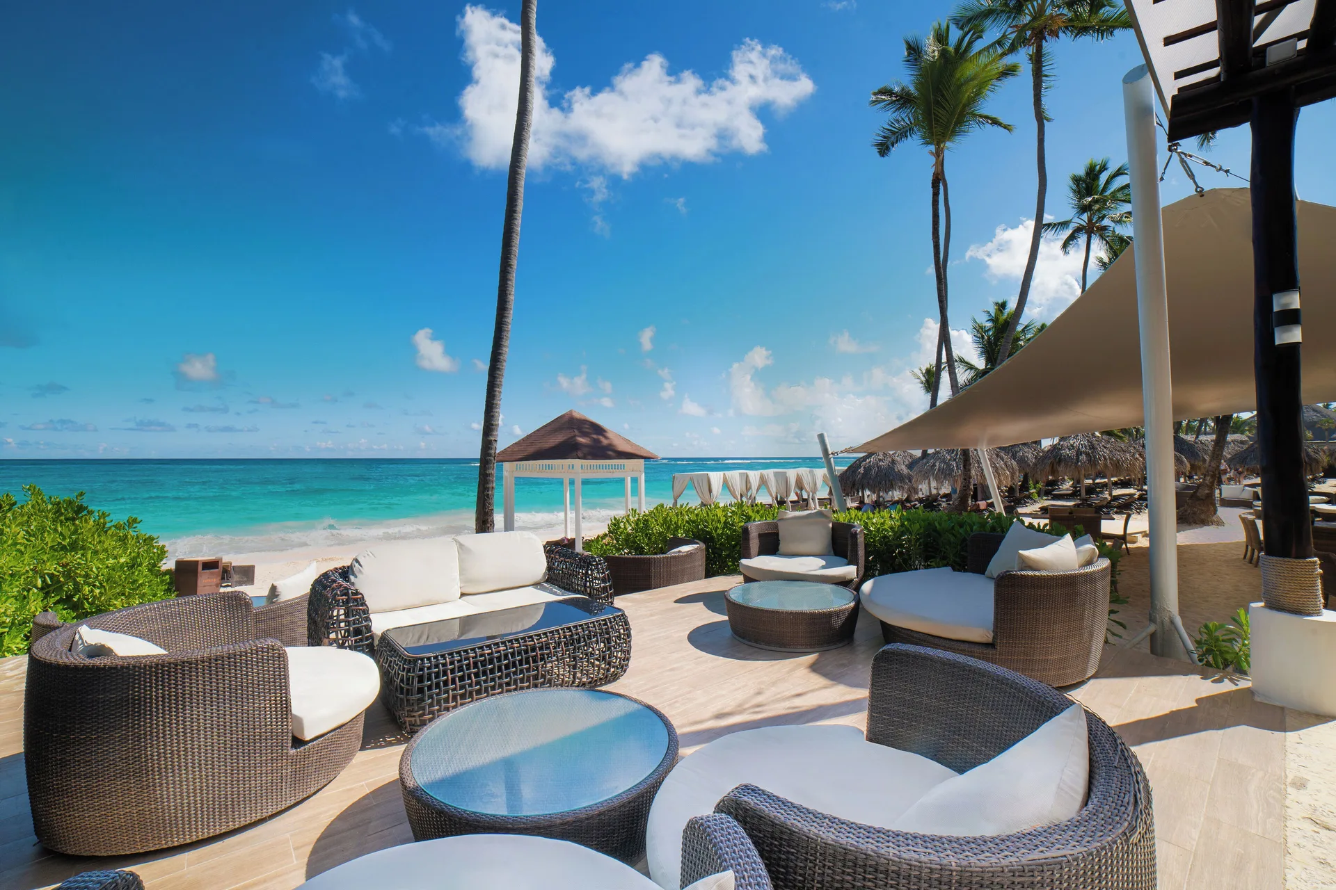 Oceanfront lounge chairs on a shaded terrace at Royalton Hideaway Punta Cana Resort & Casino.