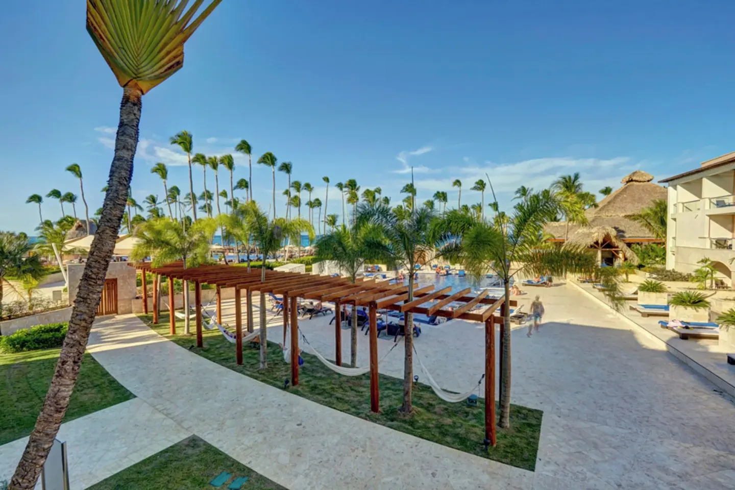 Palm-lined resort grounds with loungers and hammocks at Royalton Hideaway Punta Cana Resort & Casino.