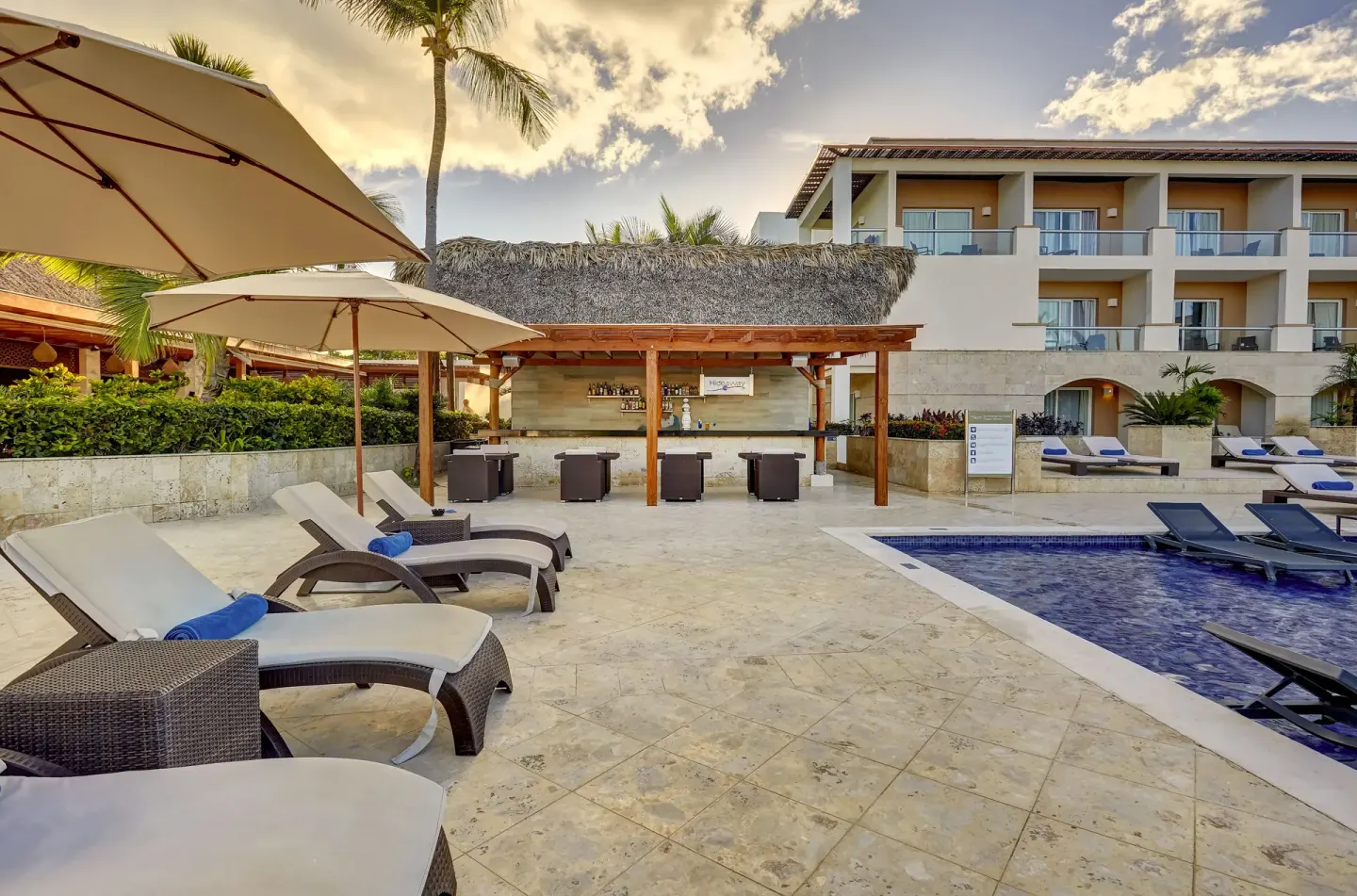 Pool deck with loungers, umbrellas, and a bar at Royalton Hideaway Punta Cana Resort & Casino.