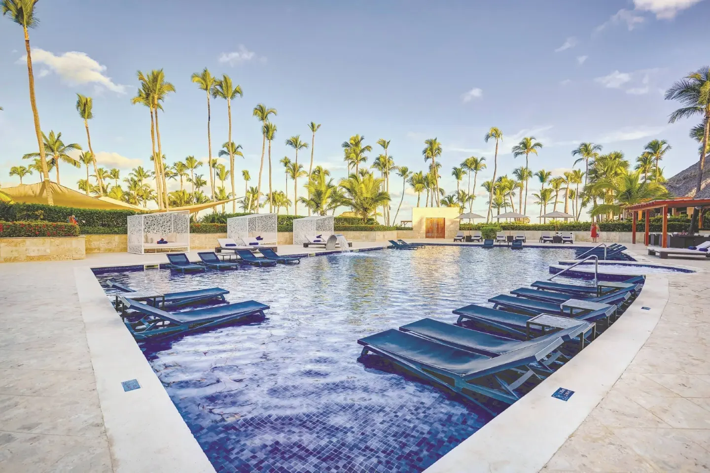 Pool with submerged loungers and palms at Royalton Hideaway Punta Cana Resort & Casino.