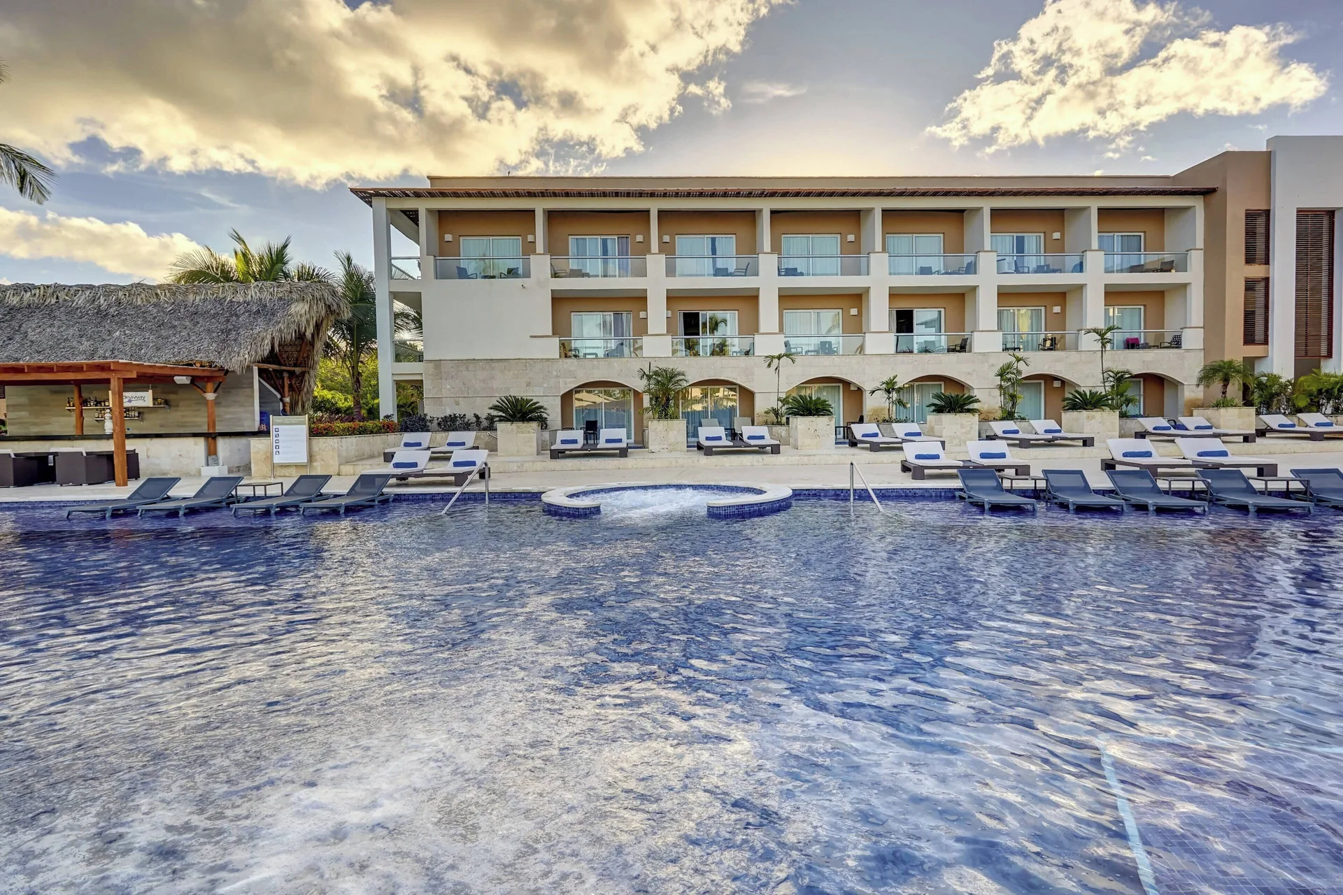 Pool, loungers, and guest building at Royalton Hideaway Punta Cana Resort & Casino.