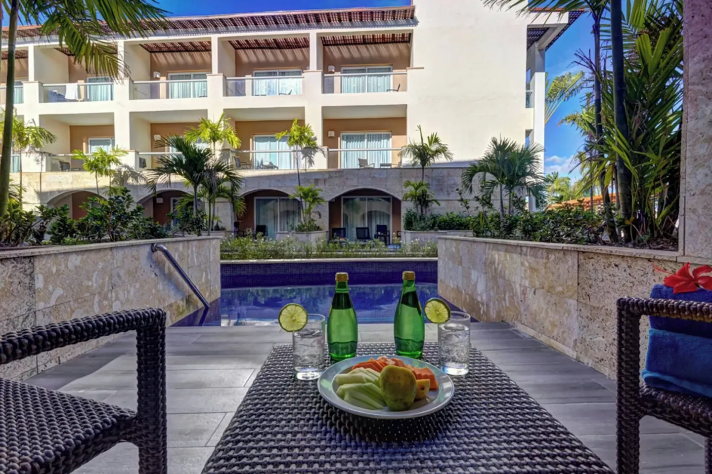 Terrace table with drinks and fruit by a swim-out pool at Royalton Hideaway Punta Cana Resort & Casino.