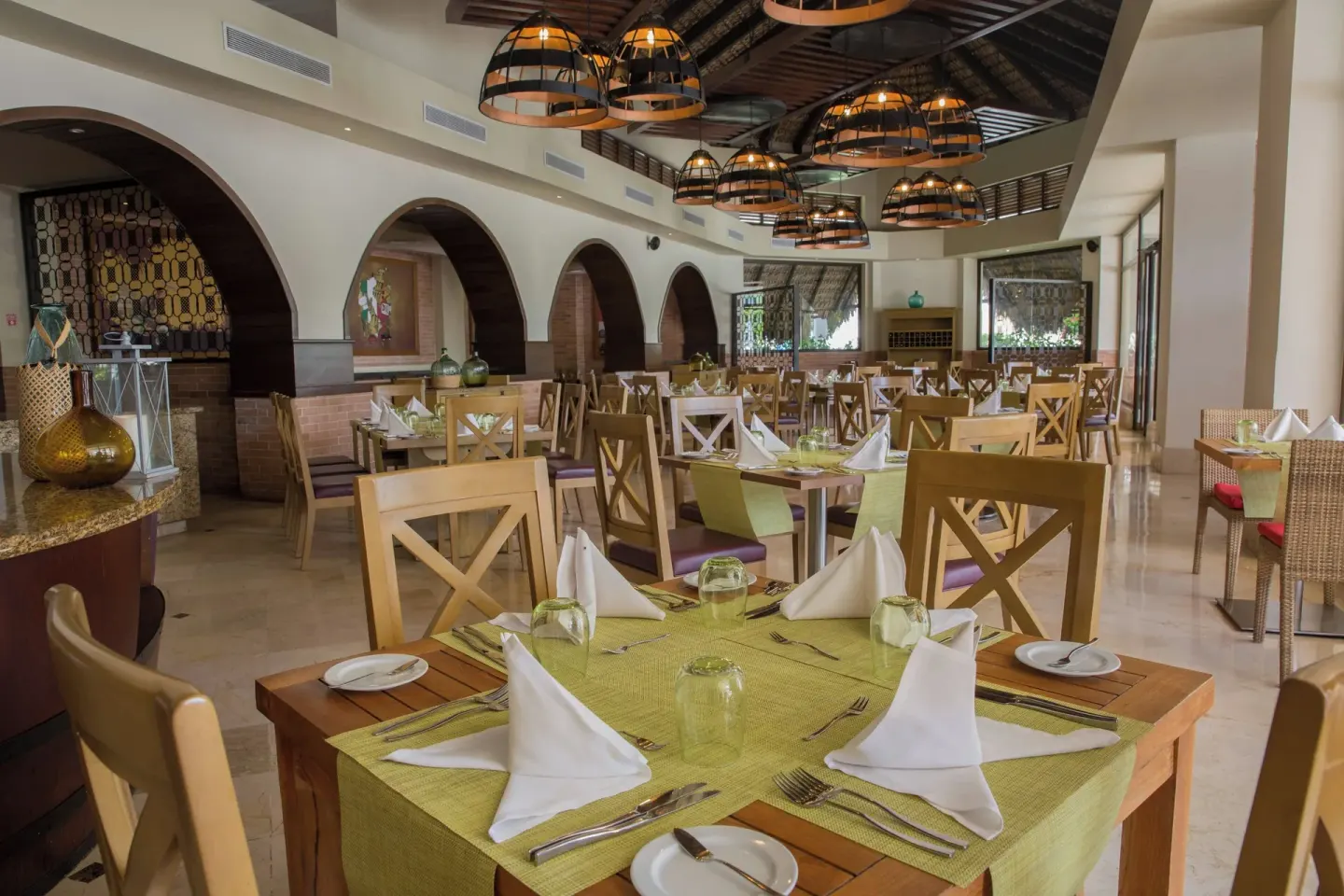 Set restaurant tables in an arched dining room at Royalton Hideaway Punta Cana Resort & Casino.