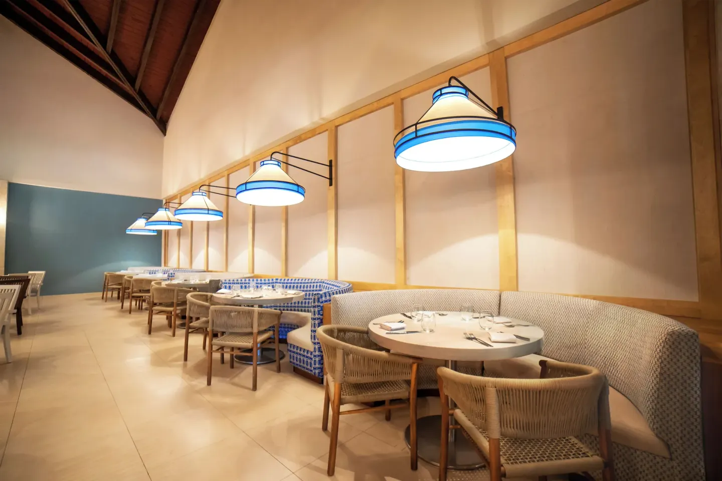 Blue-accented banquette seating in a dining room at Royalton Hideaway Punta Cana Resort & Casino.