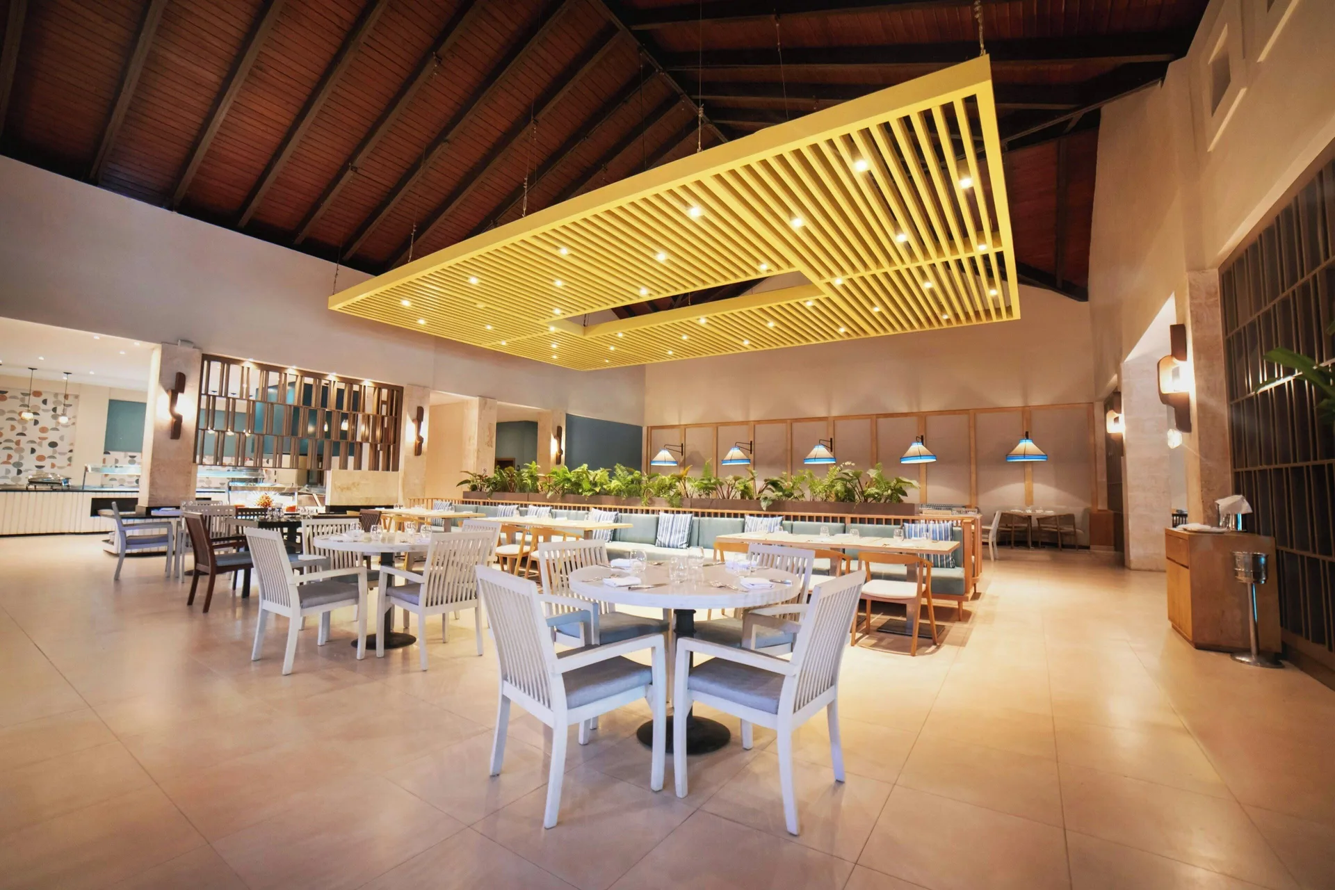Bright restaurant with white chairs and a large ceiling feature at Royalton Hideaway Punta Cana Resort & Casino.