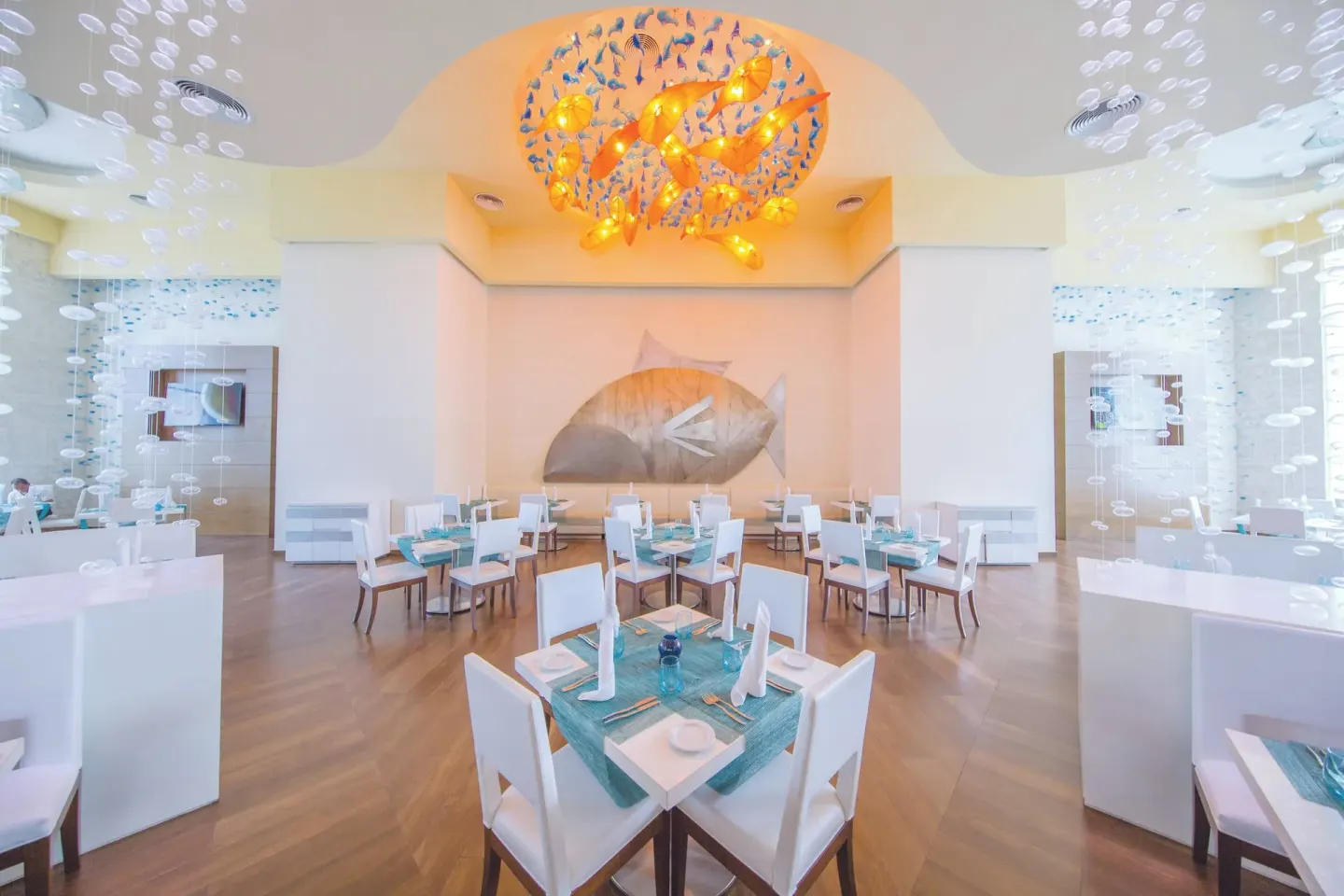 Sea-themed white dining room with fish decor at Royalton Hideaway Punta Cana Resort & Casino.