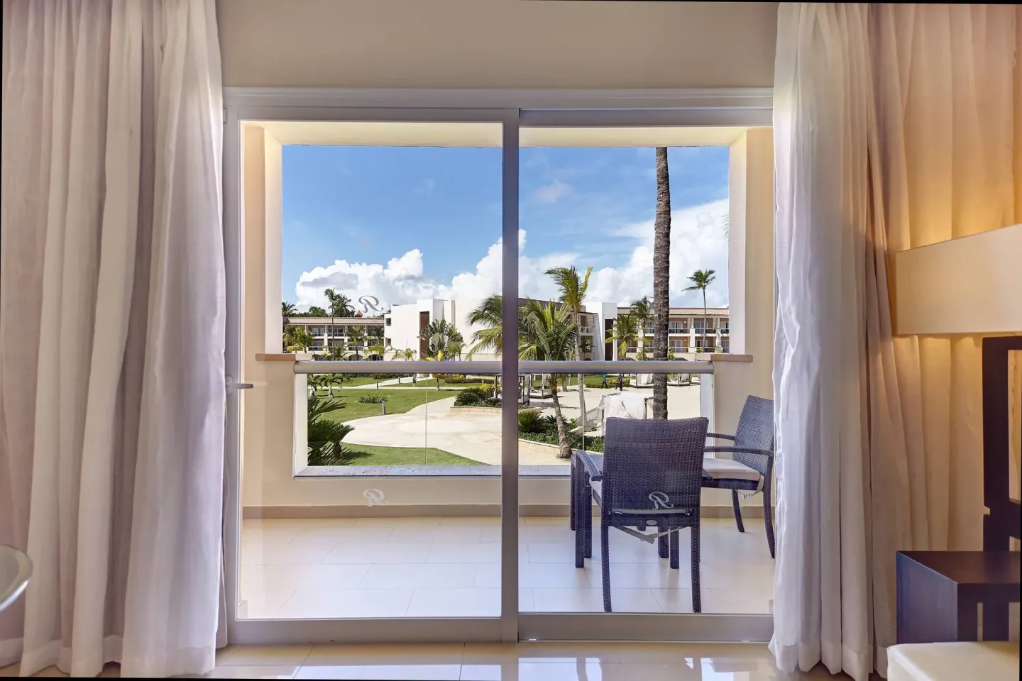 Sliding glass doors open to the balcony of the Honeymoon Jacuzzi Suite Diamond Club at Royalton Hideaway Punta Cana Resort &