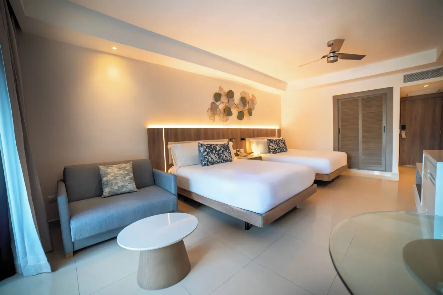 Luxury Room with two beds and gray sofa at Royalton Hideaway Punta Cana Resort & Casino.